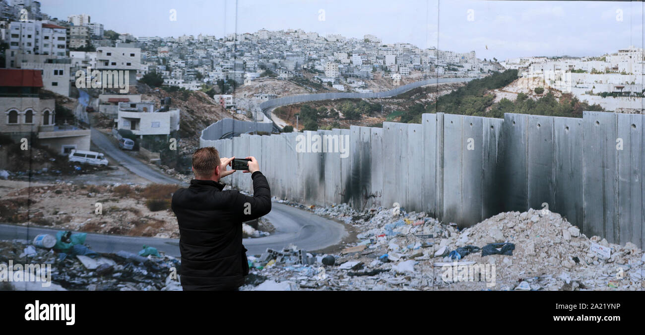 Un homme prend des photos d'un mur de paix de Belfast qui expose des photos par photographe allemand Kai Wiedenhofer du monde ? ? ?s murs frontaliers, d'avance sur Brexit. Banque D'Images