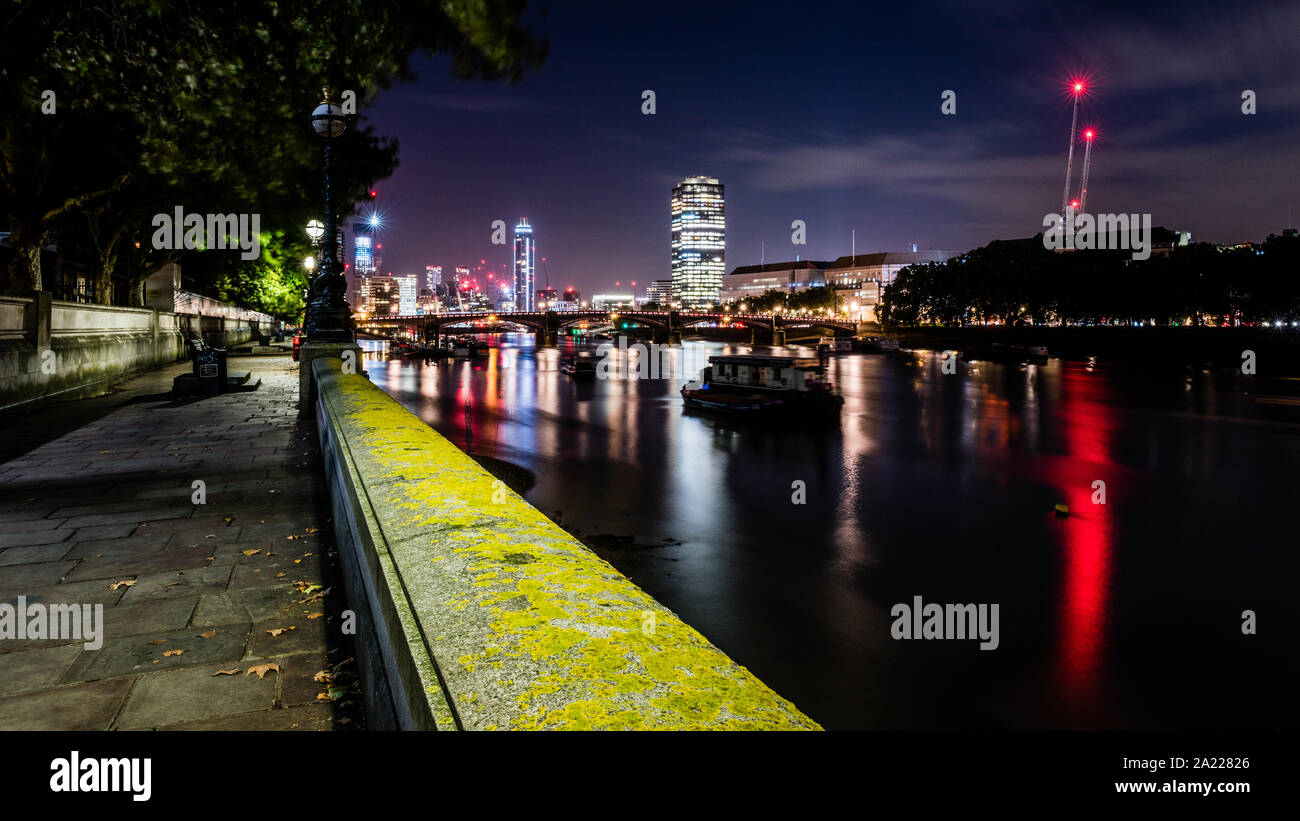 Dans la distance, Battersea Power Station & City Lights rejeté dans la Tamise. Image réalisée à partir d'exposition lente Thames Path vers Lambeth Bridge Banque D'Images