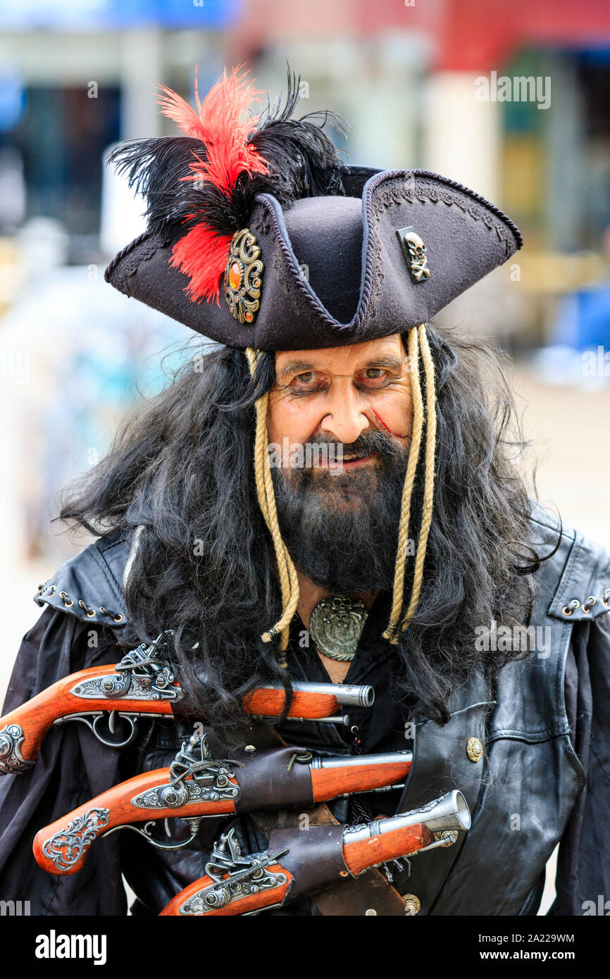 Jour pirate dans Hastings, Royaume-Uni. Close up portrait of man dressed as Blackbeard avec barbe noire et trois pistolets attaché à la poitrine. Eye-contact. Banque D'Images
