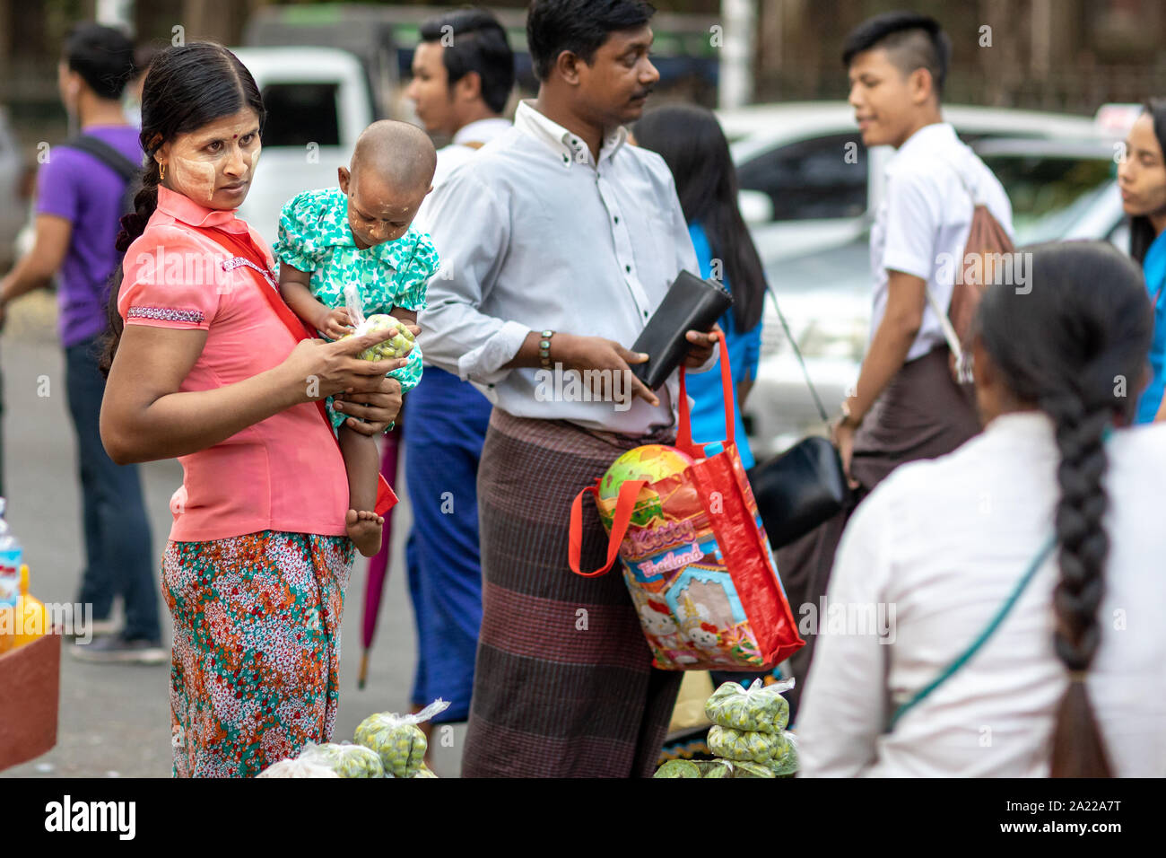 Mère avec enfant de l'achat de nourriture dans les rues de Yangon, Myanmar. Banque D'Images