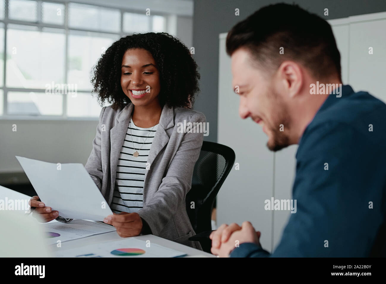 Deux jeunes gens d'affaires de joyeuse soirée à discuter le projet sur le lieu de travail Banque D'Images