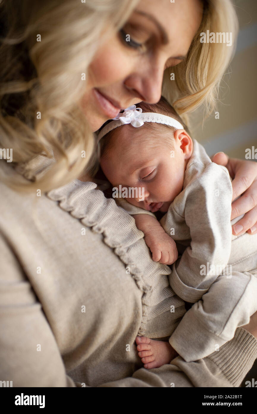 Heureusement mère fille nouveau-né tient contre sa poitrine à la maison Banque D'Images