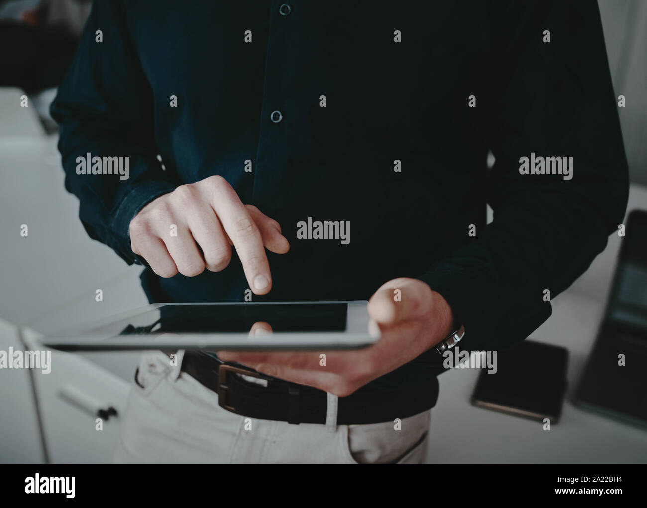 Le milieu de l'article d'un homme d'affaires bien habillés de toucher son écran de tablette numérique avec le doigt Banque D'Images