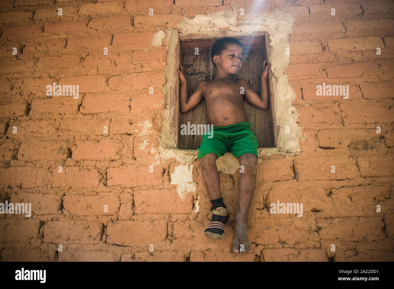 Petit garçon du nord de quilombo brésilien assis sur la fenêtre Banque D'Images