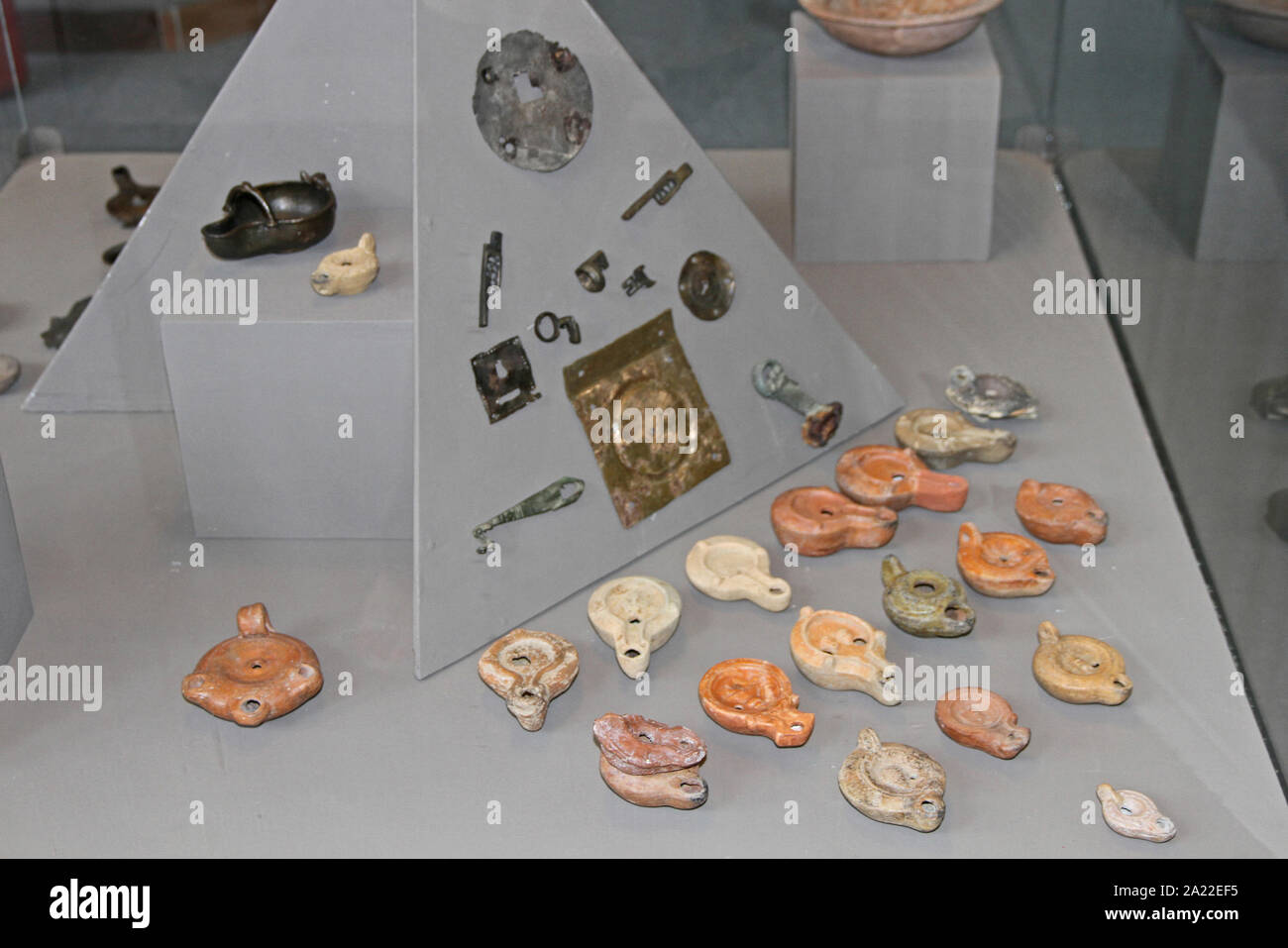 Collection de lampes en argile et ornements métalliques et mouchettes affichée en gaine de verre au Musée National Archéologique Djerdap, Beograd, Serbie. Banque D'Images