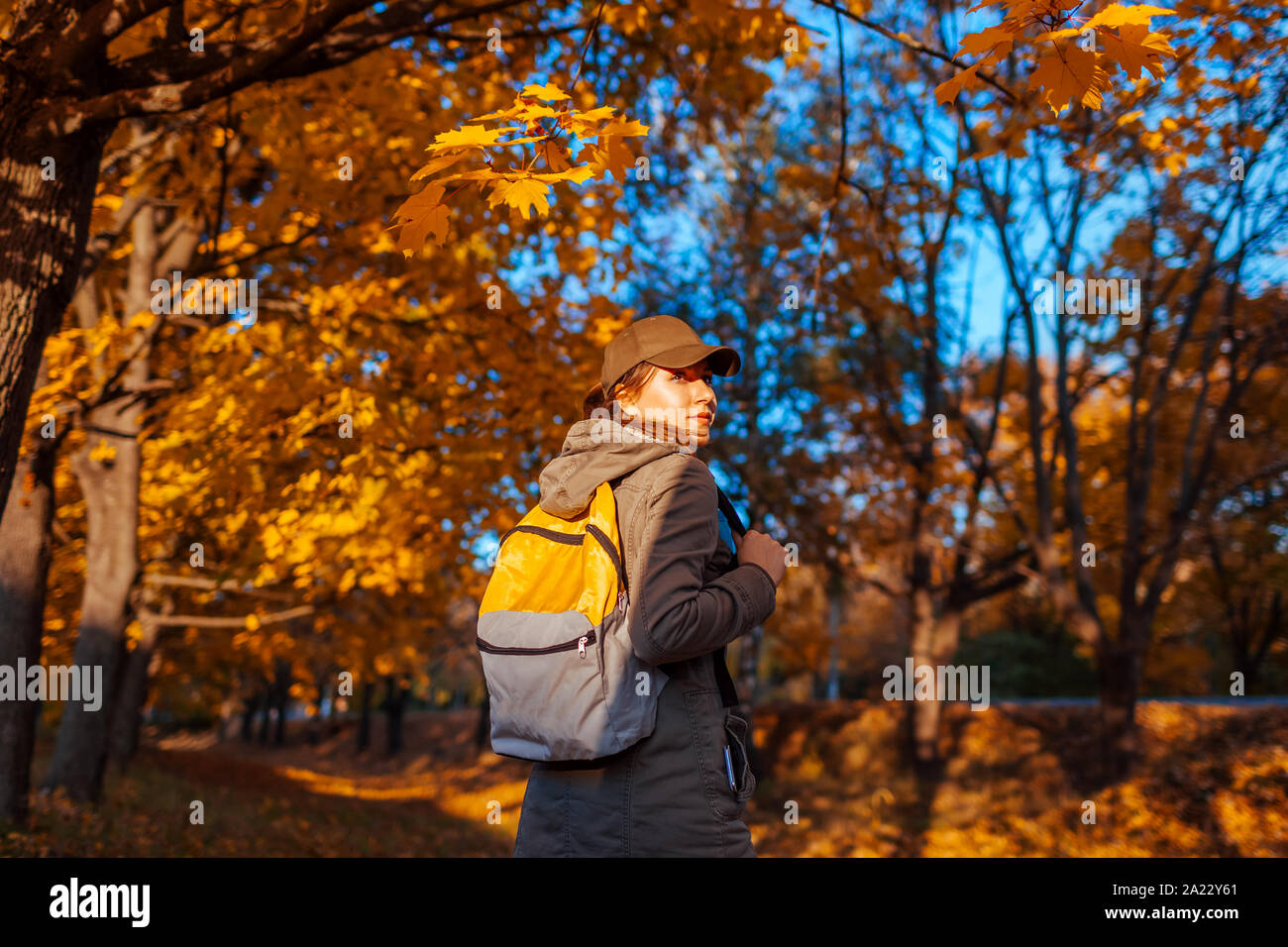 Sac à dos randonnée touristique avec en forêt d'automne. Jeune femme au coucher du soleil voyage Banque D'Images