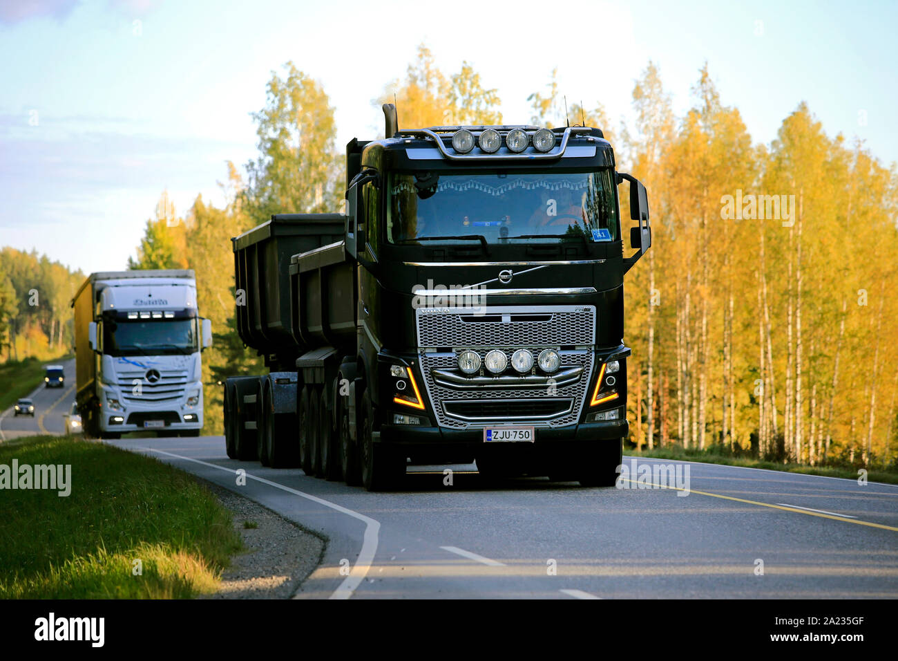 Salo, Finlande. Le 27 septembre 2019. Volvo FH16 noir en face de gravel remorque et semi-remorque Mercedes-Benz transporter des marchandises le long de la route au coucher du soleil d'automne. Banque D'Images