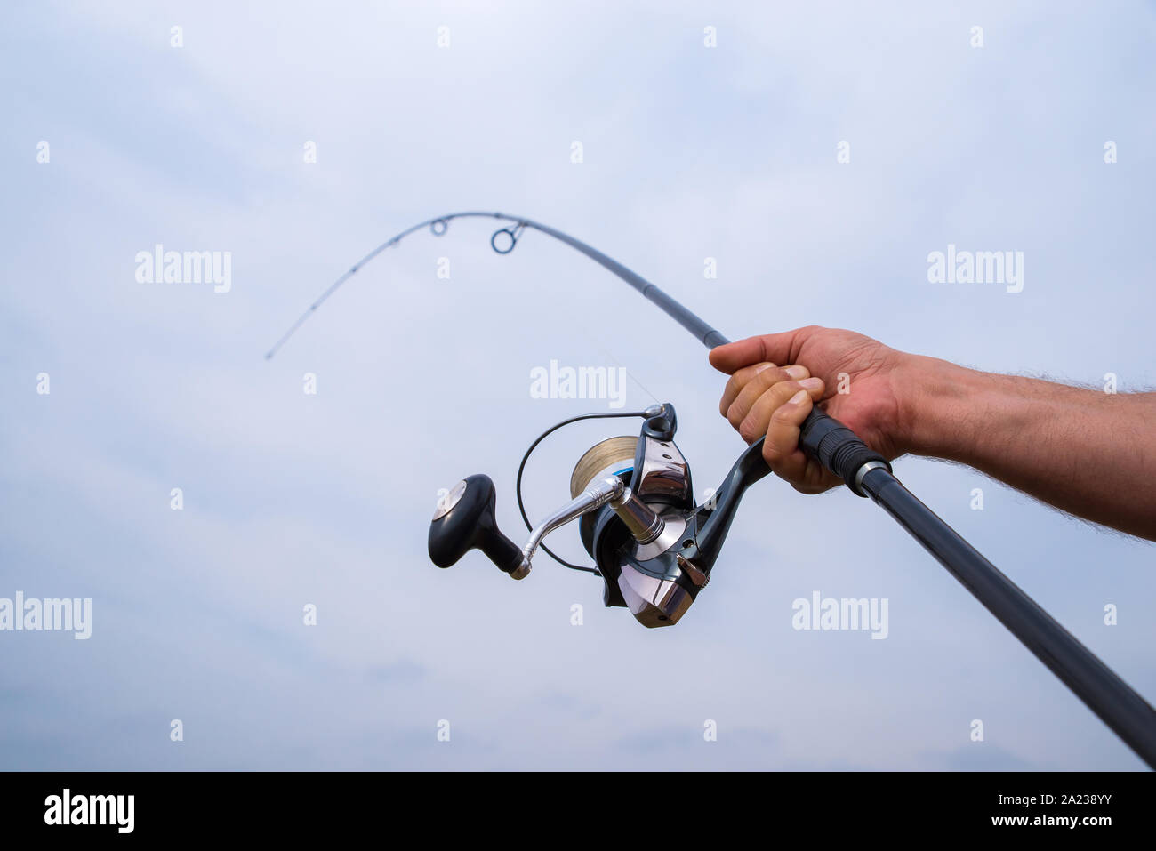 Homme main tenant une canne à pêche et le moulinet Photo Stock - Alamy