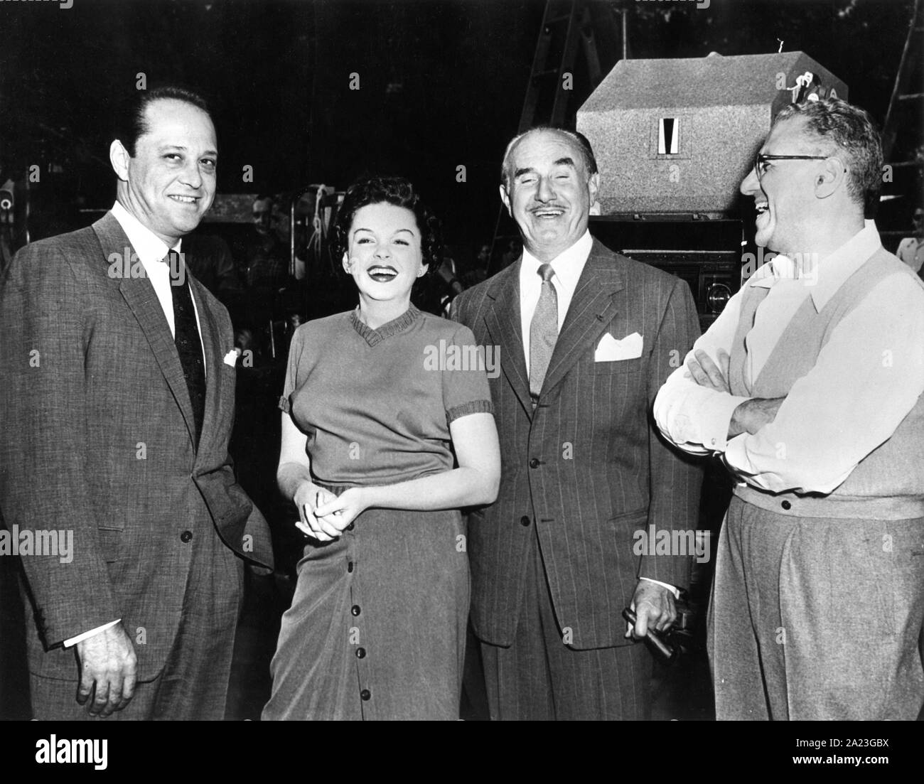 JUDY GARLAND avec troisième mari SID LUFT (à gauche), producteur JACK L. WARNER et réalisateur GEORGE CUKOR sur le plateau de tournage avec franchise UNE ÉTOILE EST NÉE 1954 Entreprises Transcona / Warner Bros. Banque D'Images