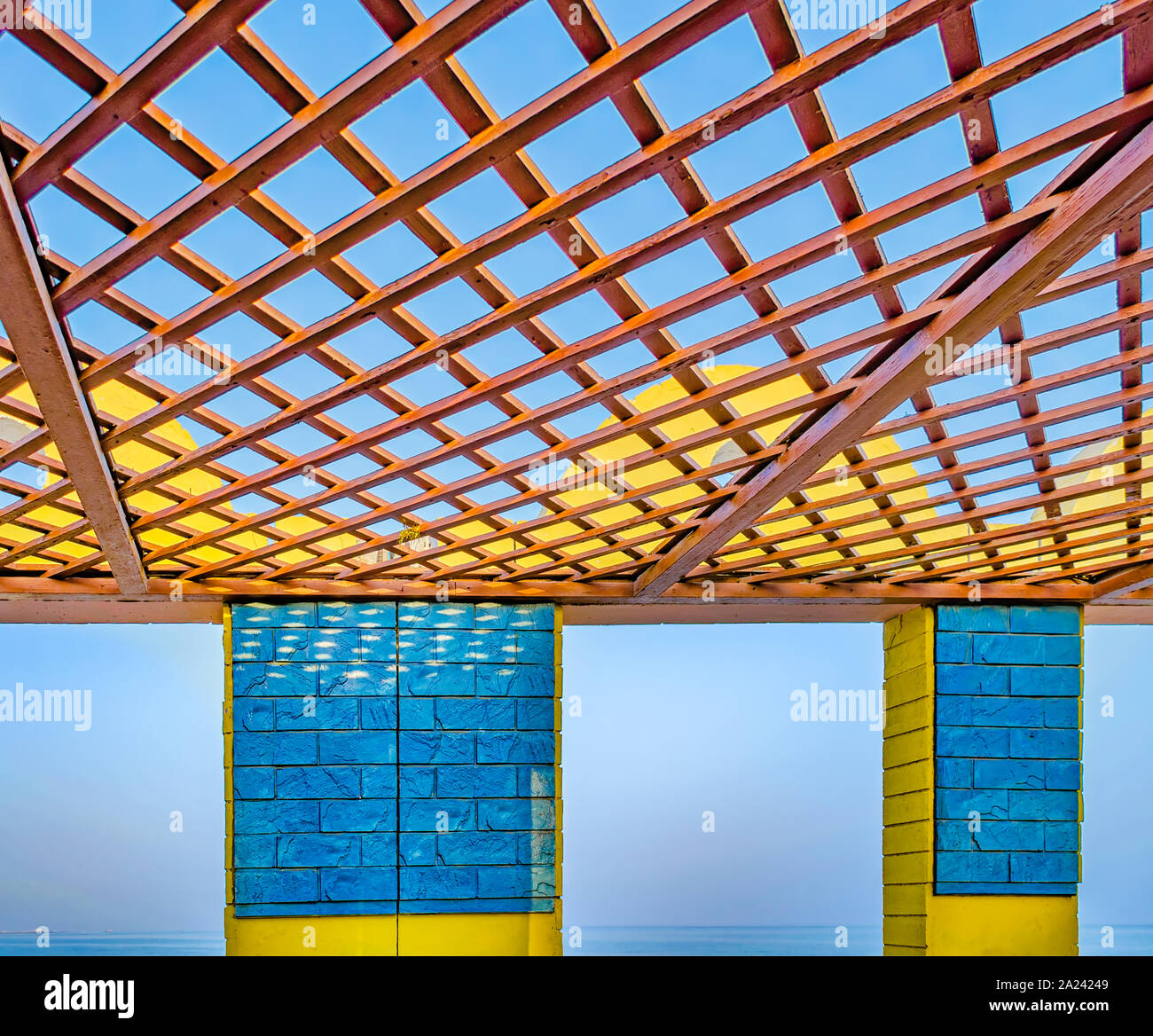 Jaune et bleu abri de plage ouvert avec panneau en bois sur le toit face à une mer calme. De Mascate, Oman. Banque D'Images