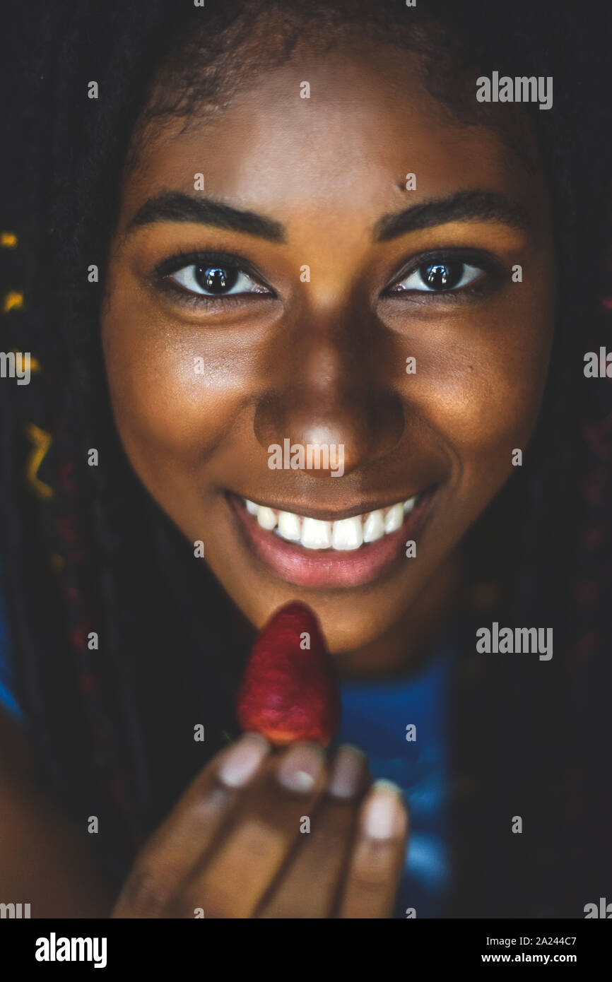 Jeune femme noire de manger une fraise, Cali, Colombie Banque D'Images