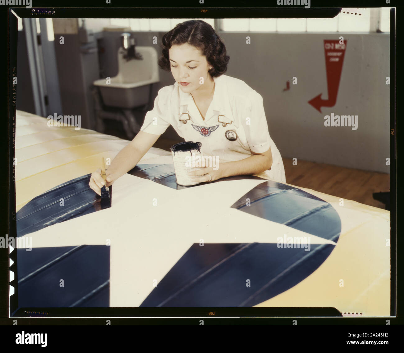 Peinture de l'insigne américain sur les ailes d'avions est un travail que Mme Irma Lee McElroy, un ancien employé de bureau le fait avec précision et de zèle patriotique. Mme McElroy est un employé du service civil à la Naval Air Base, Corpus Christi, Texas. Son mari est un instructeur de vol Banque D'Images