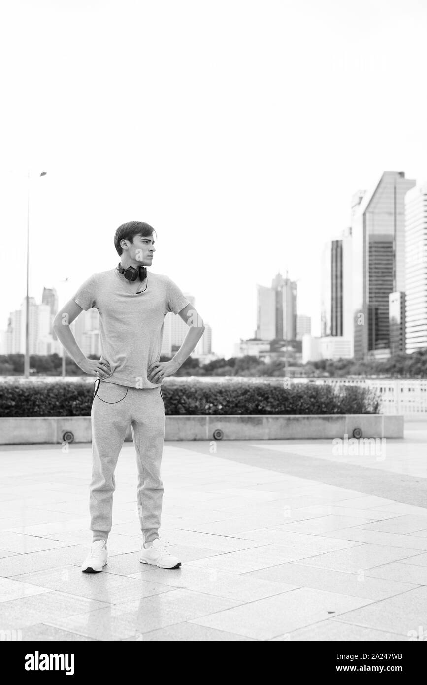Beau jeune homme portant un casque tout en vous relaxant dans le parc Banque D'Images