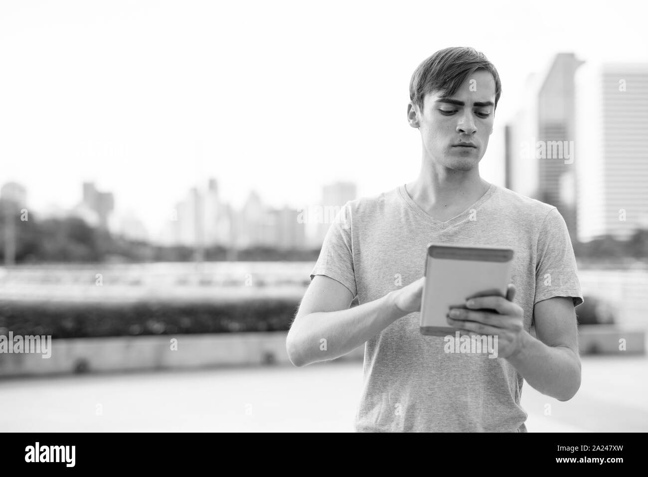 Handsome Young man using digital tablet tout en vous relaxant dans le parc Banque D'Images