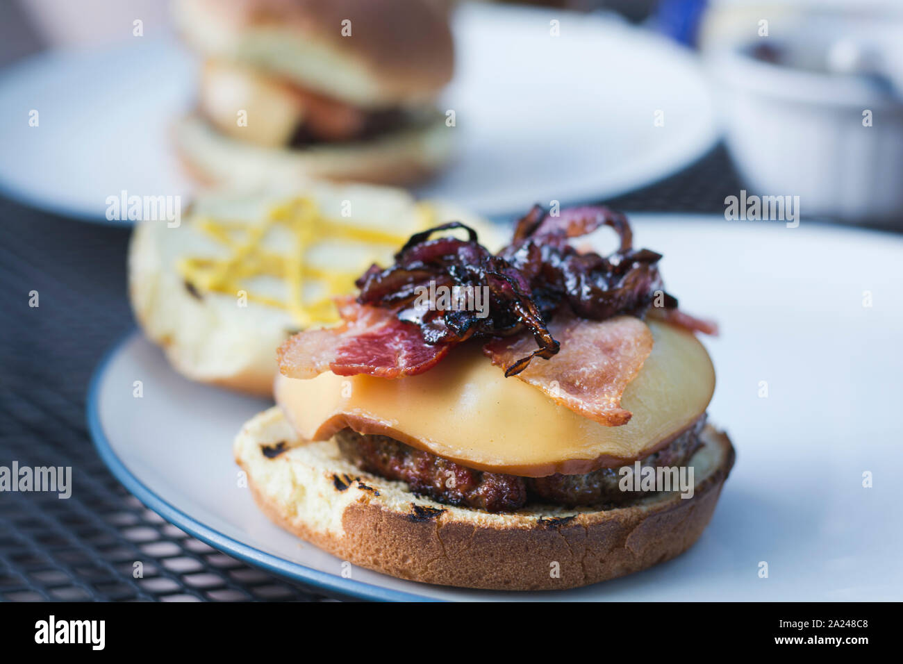 La fin de l'été délicieux hamburgers grillés avec du bacon et oignons sautés fromage de gouda fondu. Banque D'Images