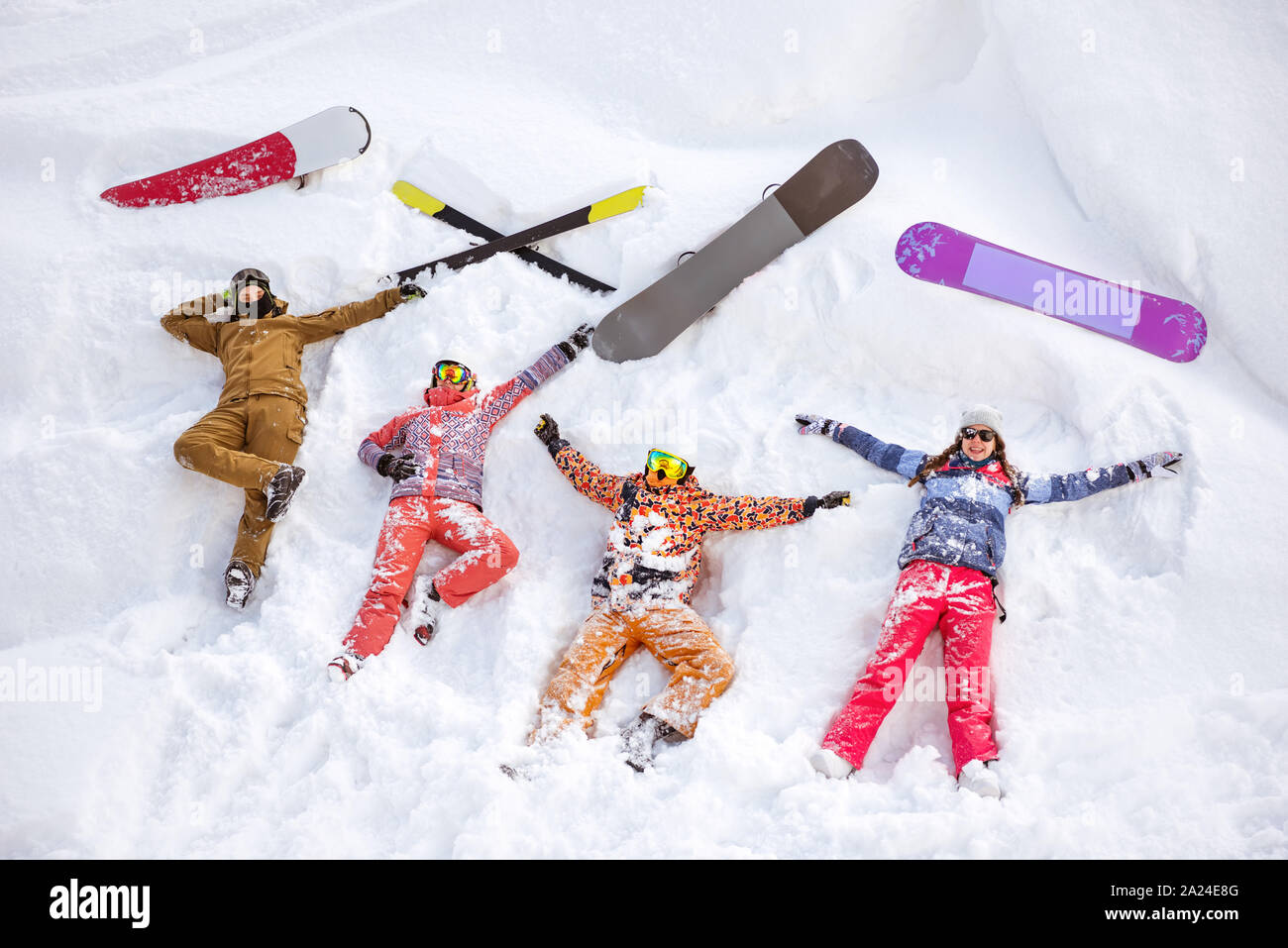 Quatre amis heureux skieurs et surfeurs s'amusent et couché sur la neige avec le ski et snowboards. Vue aérienne Banque D'Images