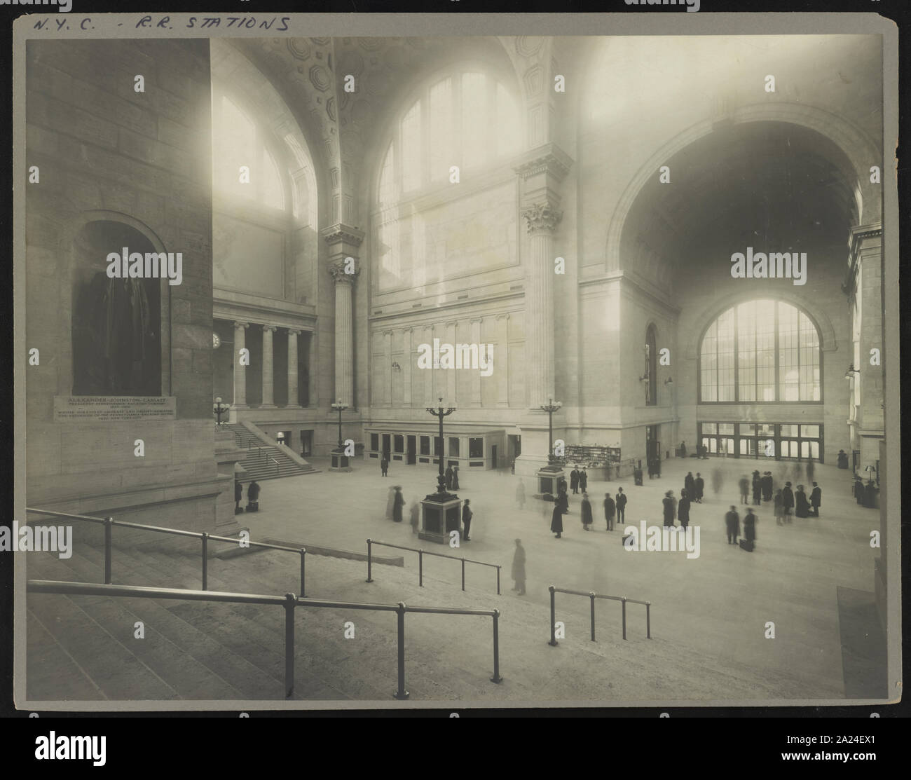 Les passagers dans la salle d'attente à la Pennsylvania Station, New York, New York, avec statue de Alexander Cassatt Johnston, président de la Pennsylvania Railroad Company, dans des créneaux sur le mur Banque D'Images