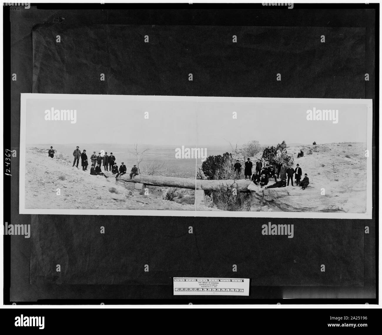 Pont pétrifiée, forêt pétrifiée de l'Arizona ; Groupe d'hommes debout de chaque côté du pont. ; Banque D'Images