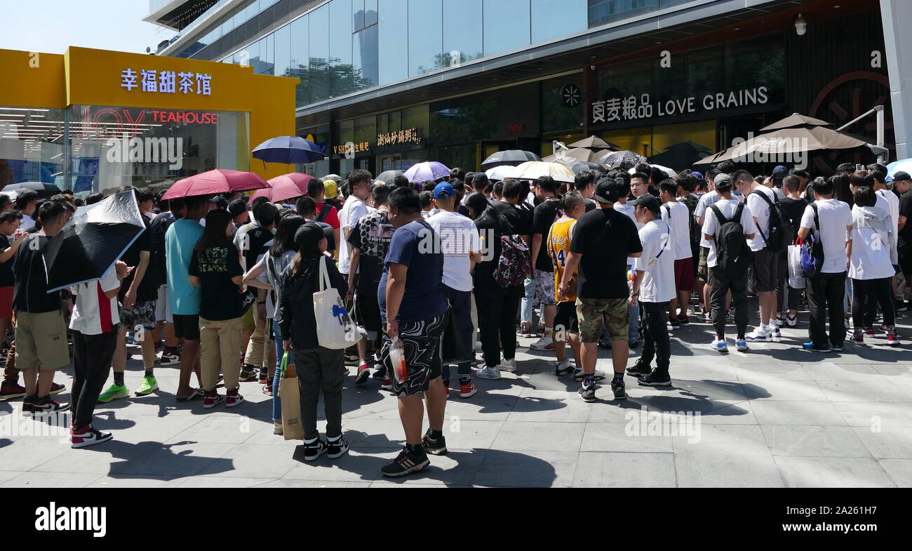 Les jeunes Chinois à la mode foule se rassemble à l'extérieur d'un magasin pour prendre part à un tirage au sort pour designer chaussures formateur unique. Beijing, Chine Banque D'Images