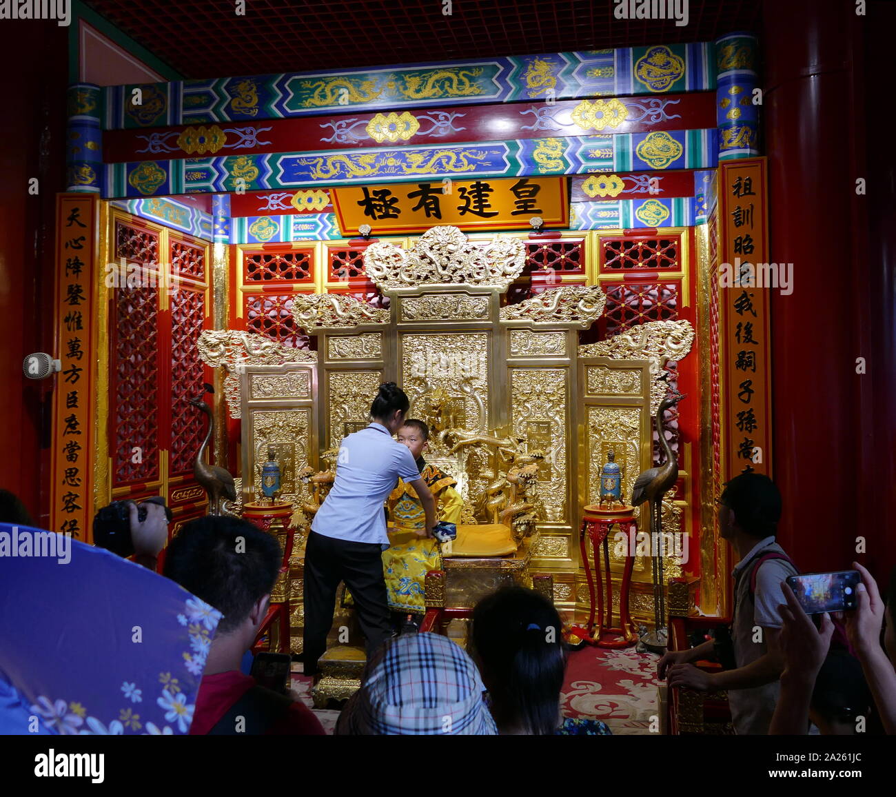 Enfant re-enacting le rôle du dernier empereur de Chine Pu Yi assis sur une réplique du Dragon trône. Comme le dragon fut l'emblème de la divine puissance impériale, le trône de l'Empereur, qui était considéré comme un Dieu vivant, était connu comme le Dragon trône Banque D'Images