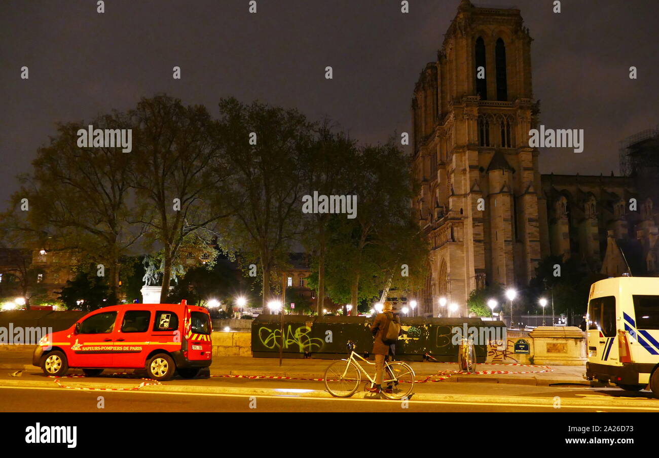 Scène montrant l'impact de l'incendie qui a endommagé la cathédrale Notre Dame de la nuit, le feu a été éteint. les véhicules d'urgence se tiennent à l'extérieur l'éclairage de la cathédrale. Banque D'Images