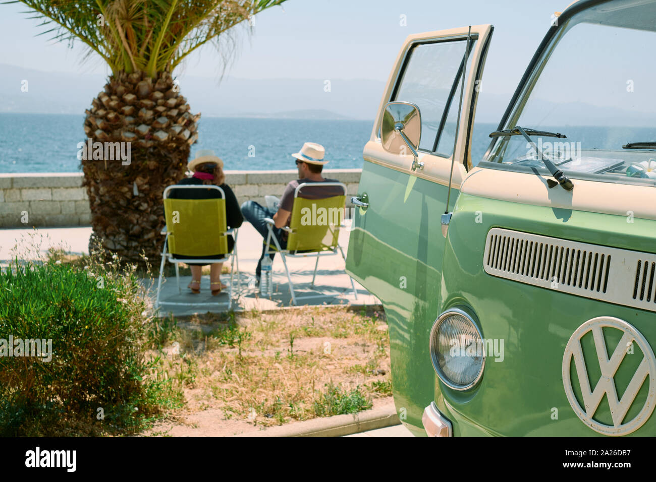 Un couple en profitant de la vue de leur retro vintage classic VW T2  Camping-Van sur la Riviera, la côte, avec un palmier dans l'été Photo Stock  - Alamy