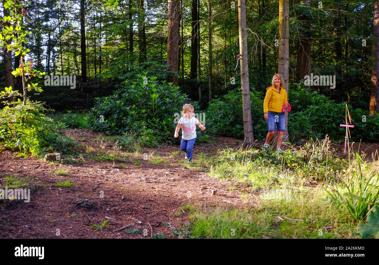 Jeune fillette de deux ans à jouer dans les bois avec sa grand-mère s'amusant Banque D'Images