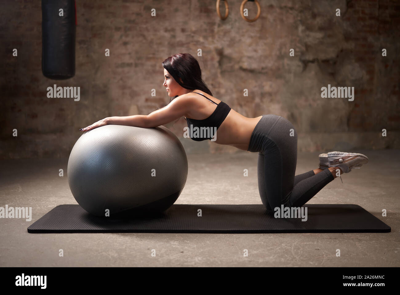 Femme Sport entraînement avec ballon de gymnastique fonctionnelle dans la salle de sport Banque D'Images