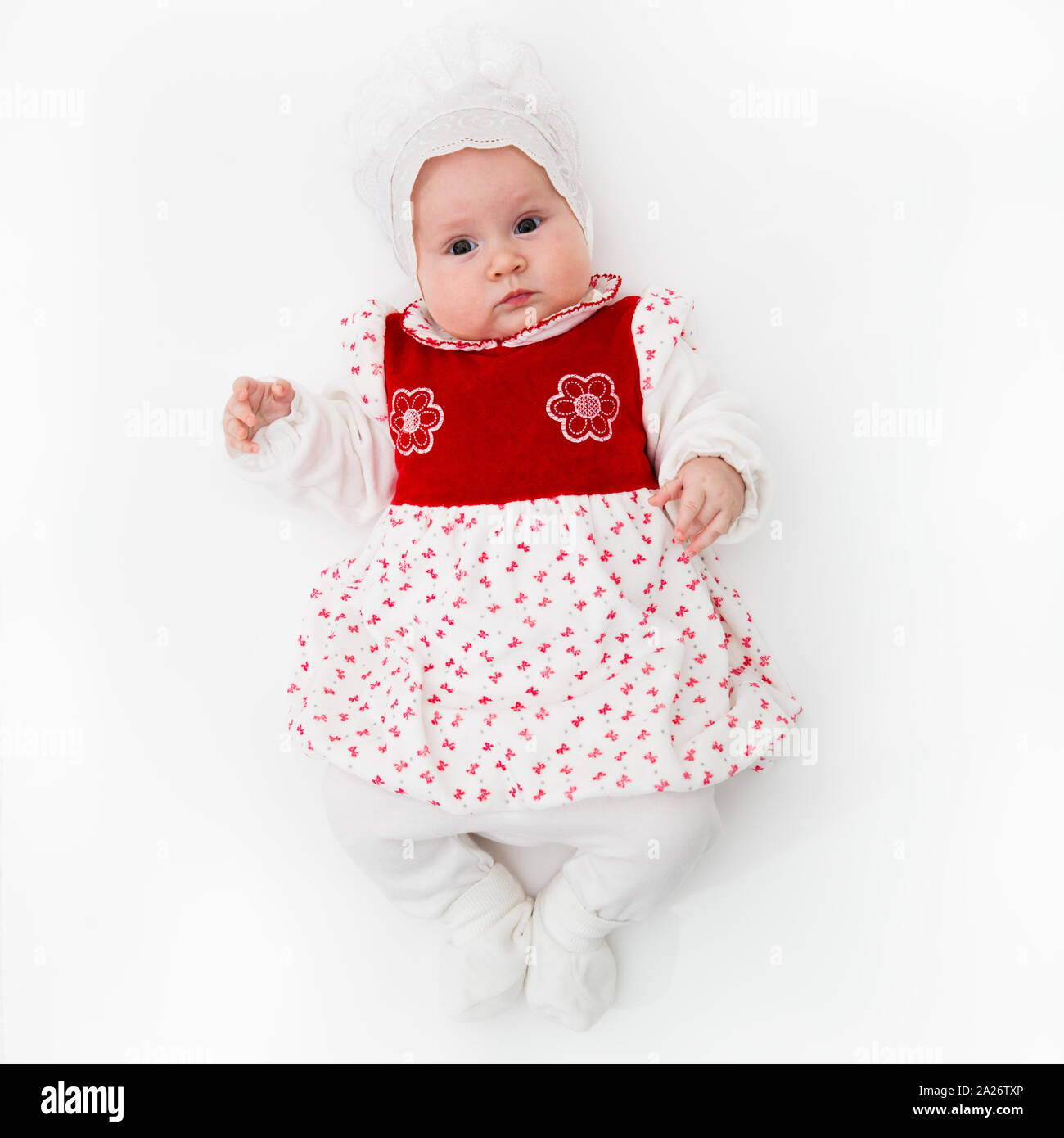 Blanc de race blanche Naissance bebe Fille dans une robe à pois rose avec  des volants sur un fond rose avec des fleurs d'un bandage sur la tête.  Regard perçant. 13 da