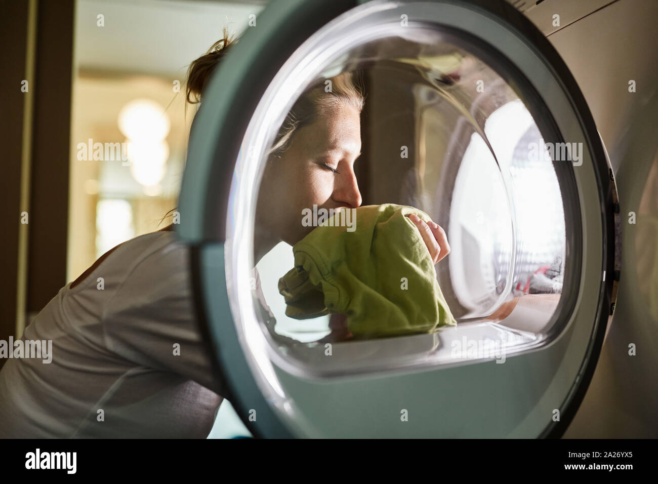 Femme les odeurs de linge propre frais de la machine de lavage après lavage Banque D'Images
