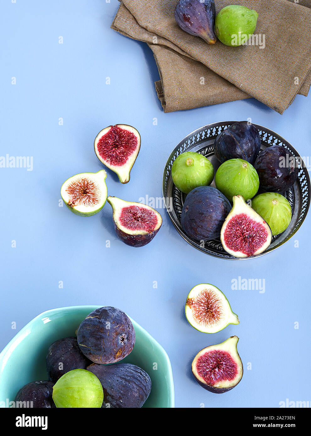 Violet et Vert frais figues sur un bol en métal et sur un fond bleu. Banque D'Images