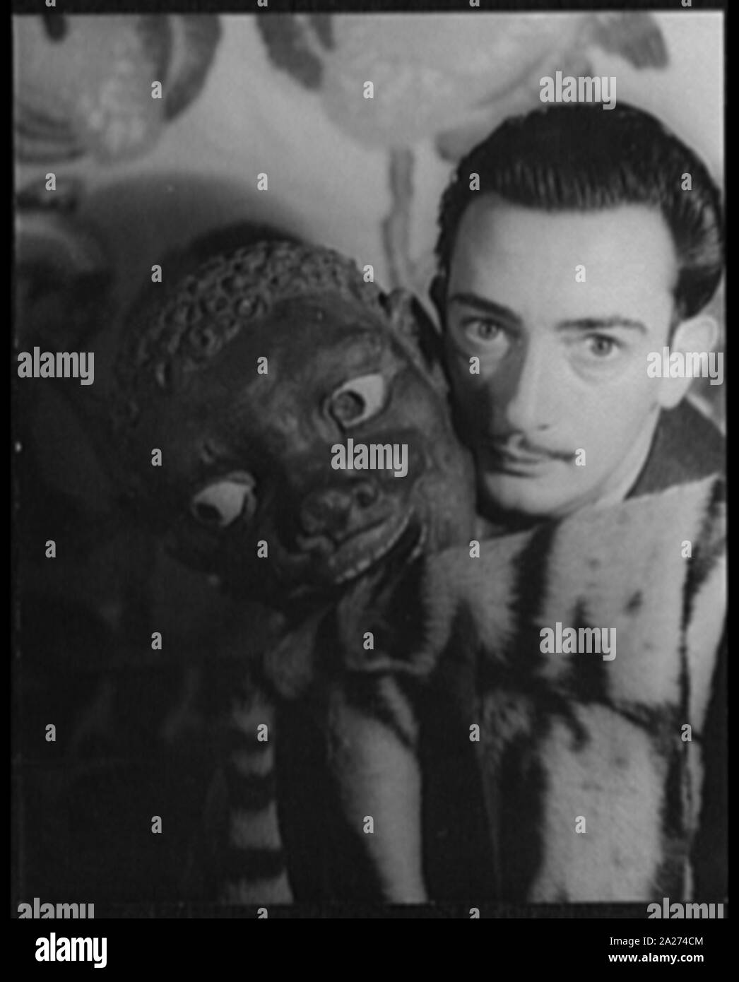 Portrait de Salvador Dali avec tête noir sculpté à côté de son visage Banque D'Images