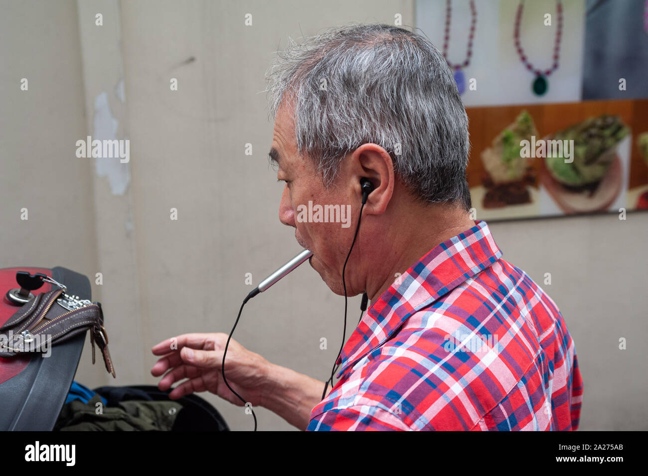 12.04.2019, Singapour, Singapour , - un homme plus âgé est à l'écoute de la musique avec des écouteurs dans Chinatown Chinatown le quartier. 0SL190412D008CAROEX.J Banque D'Images 12.04.2019, Singapour, Singapour , - un homme plus âgé est à l'écoute de la musique avec des écouteurs dans Chinatown Chinatown le quartier. 0SL190412D008CAROEX.J Banque D'Images