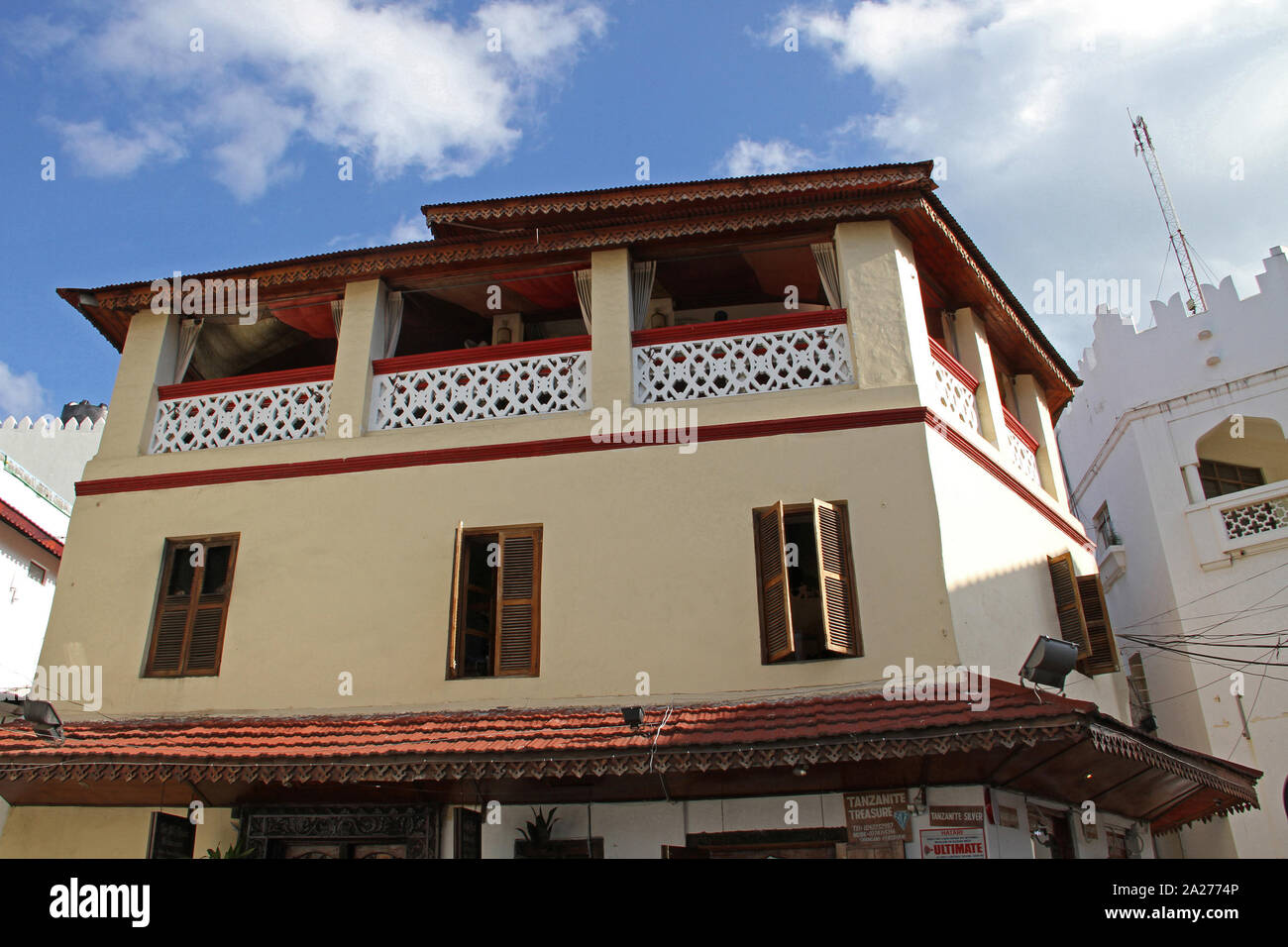 Robe rouge à l'extérieur portant des Masaï un magasin de bijoux, Stone Town, Zanzibar, Tanzanie, l'île d'Unguja. Banque D'Images Robe rouge à l'extérieur portant des Masaï un magasin de bijoux, Stone Town, Zanzibar, Tanzanie, l'île d'Unguja. Banque D'Images