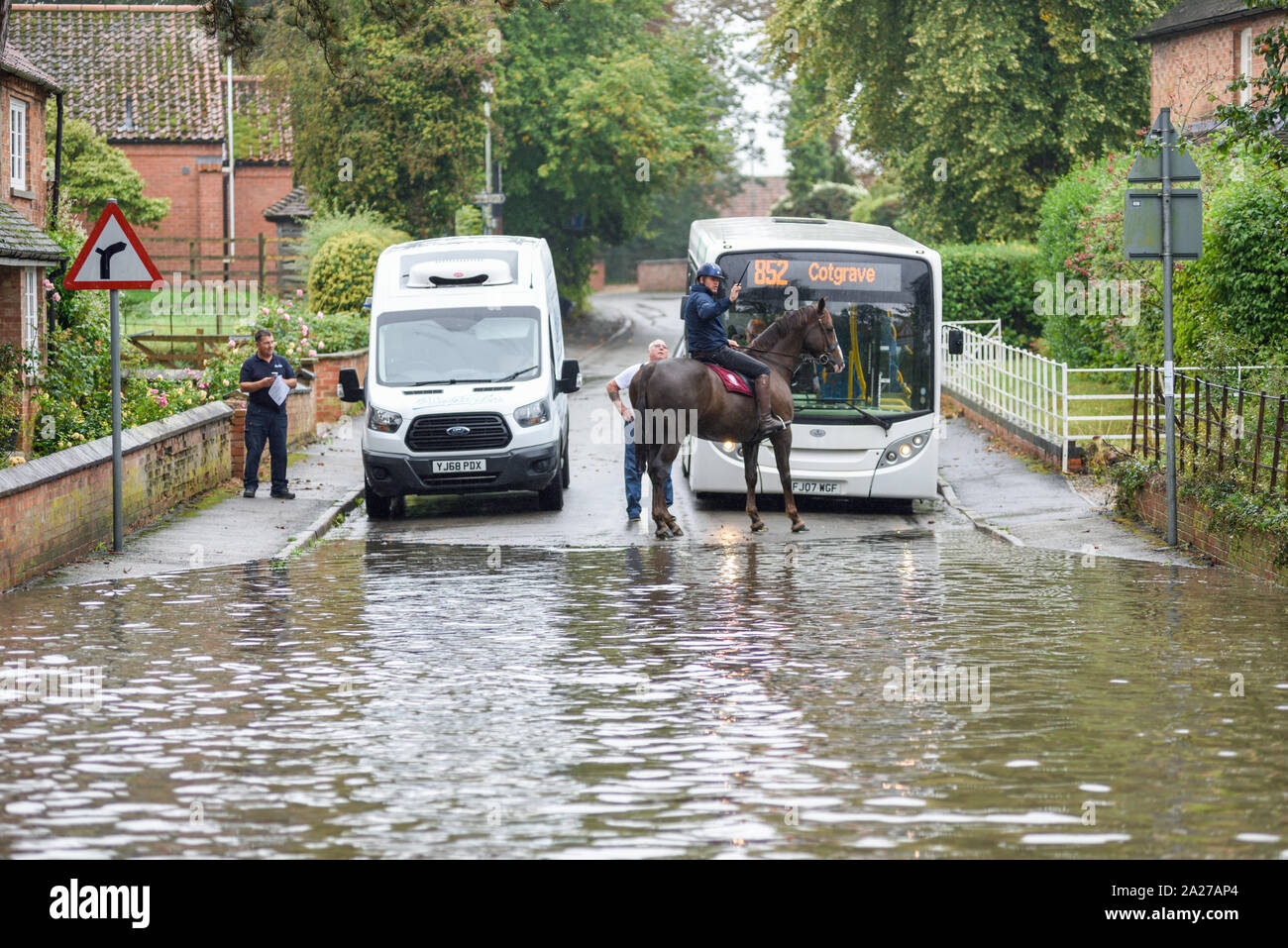 Colston Bassett, Dorset, UK : 01 octobre 2019. Frappe de la rivière qui traverse les Alpes village de Colston Bassett éclater ses banques l'inondation sur la porte à l'Église en détresse véhicules laissant. Banque D'Images