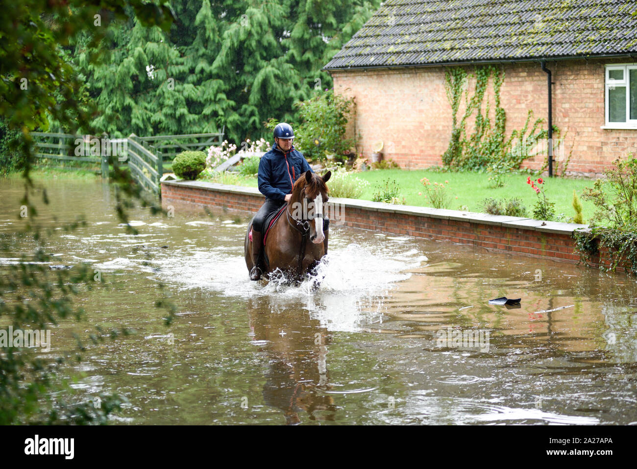Colston Bassett, Dorset, UK : 01 octobre 2019. Frappe de la rivière qui traverse les Alpes village de Colston Bassett éclater ses banques l'inondation sur la porte à l'Église en détresse véhicules laissant. Banque D'Images