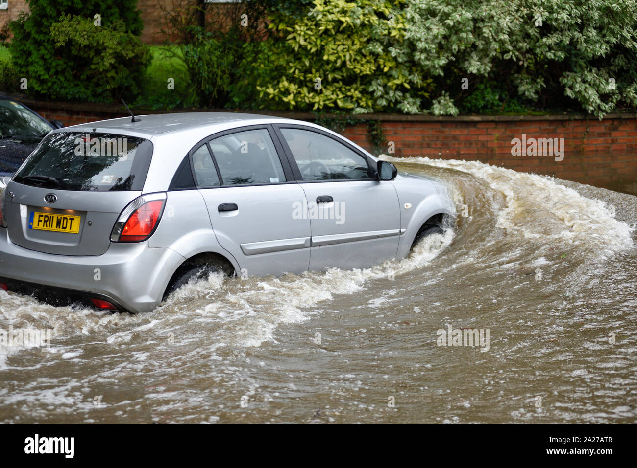 Colston Bassett, Dorset, UK : 01 octobre 2019. Frappe de la rivière qui traverse les Alpes village de Colston Bassett éclater ses banques l'inondation sur la porte à l'Église en détresse véhicules laissant. Banque D'Images