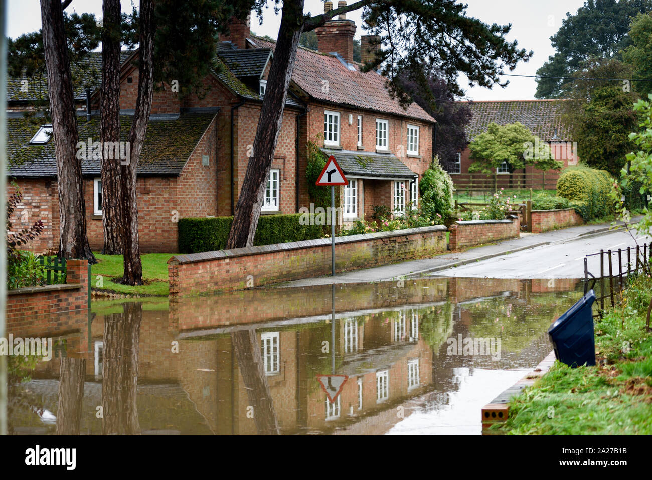 Colston Bassett, Dorset, UK : 01 octobre 2019. Frappe de la rivière qui traverse les Alpes village de Colston Bassett éclater ses banques l'inondation sur la porte à l'Église en détresse véhicules laissant. Banque D'Images