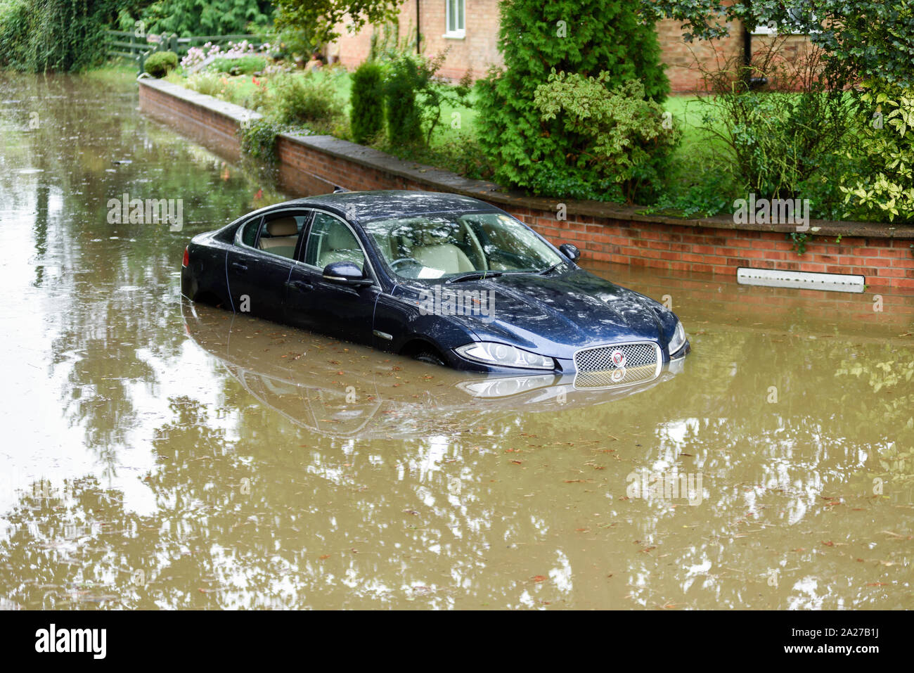 Colston Bassett, Dorset, UK : 01 octobre 2019. Frappe de la rivière qui traverse les Alpes village de Colston Bassett éclater ses banques l'inondation sur la porte à l'Église en détresse véhicules laissant. Banque D'Images
