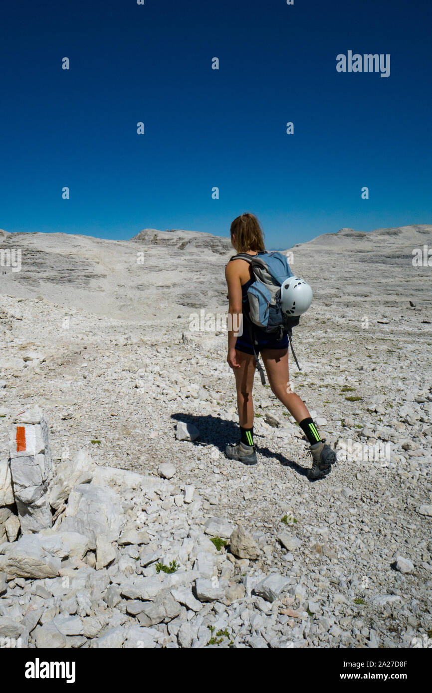 Alpiniste féminine à travers des randonnées sauvages un désert rocheux du plateau de haute montagne dans les Dolomites après une dure ascension Banque D'Images