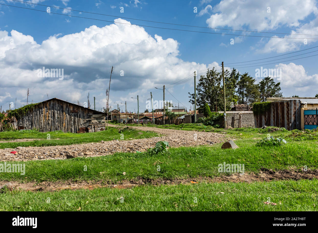 Nanyuki, comté de Laikipia, Kenya - Juin 19th, 2019 photographie de paysage : la voie en pierre entourée de petites maisons typiques du Kenya Nanyuki en périphérie. Banque D'Images