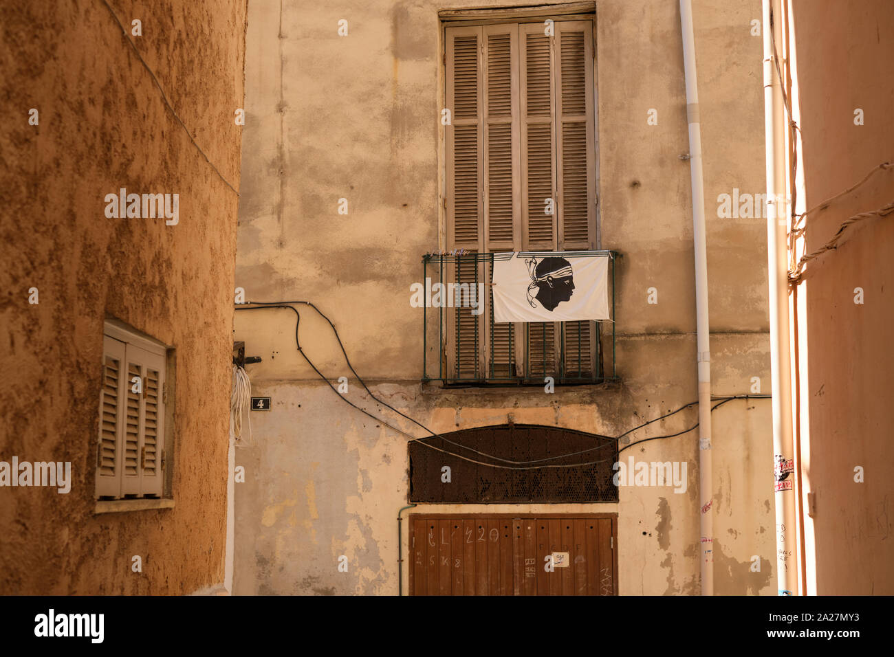 Un drapeau Corse et des armoiries d'une tête de maure avec bandana dans les petites rues de la vieille ville à Ajaccio Corse-du-Sud Corse Banque D'Images