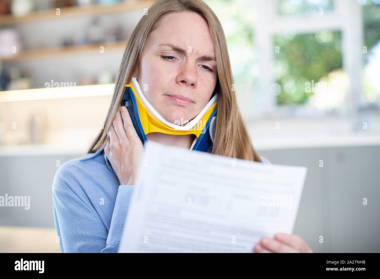 Femme à la maison pour lire une lettre envoyée après réception de blessure au cou Banque D'Images