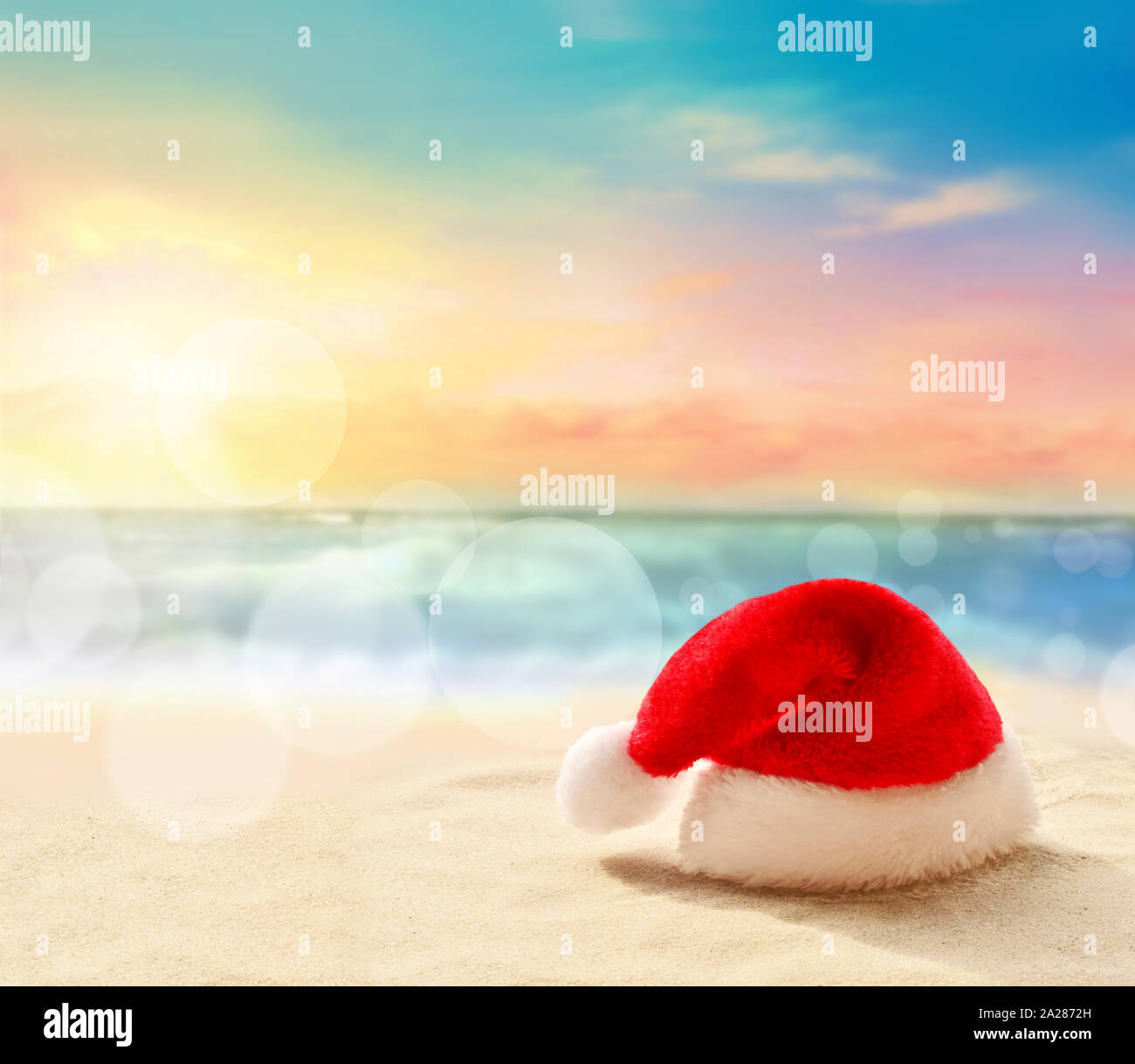 Vacances de Noël concept. Santa Claus hat sur la plage de sable de l'été. Banque D'Images