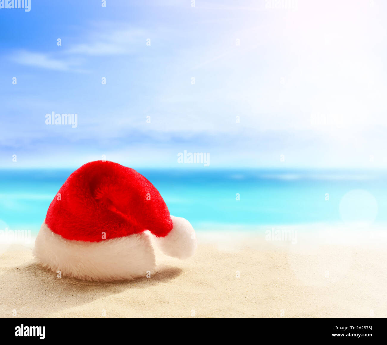Vacances de Noël concept. Santa Claus hat sur la plage de sable de l'été. Banque D'Images