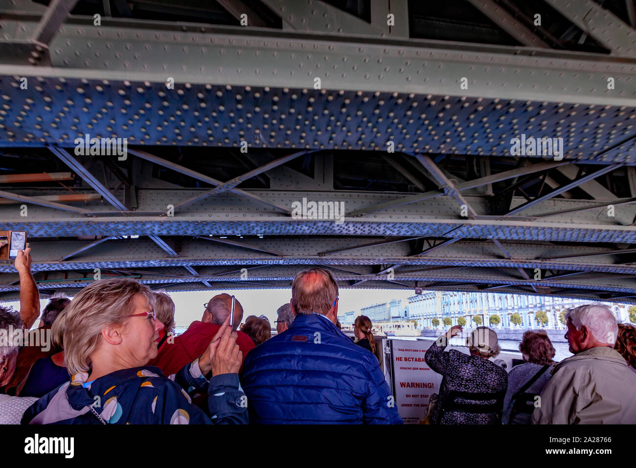 Plaisir bateau transportant les touristes de passer sous le pont du palais au cours d'une visite du matin, St Petersbugh, la Russie. Banque D'Images