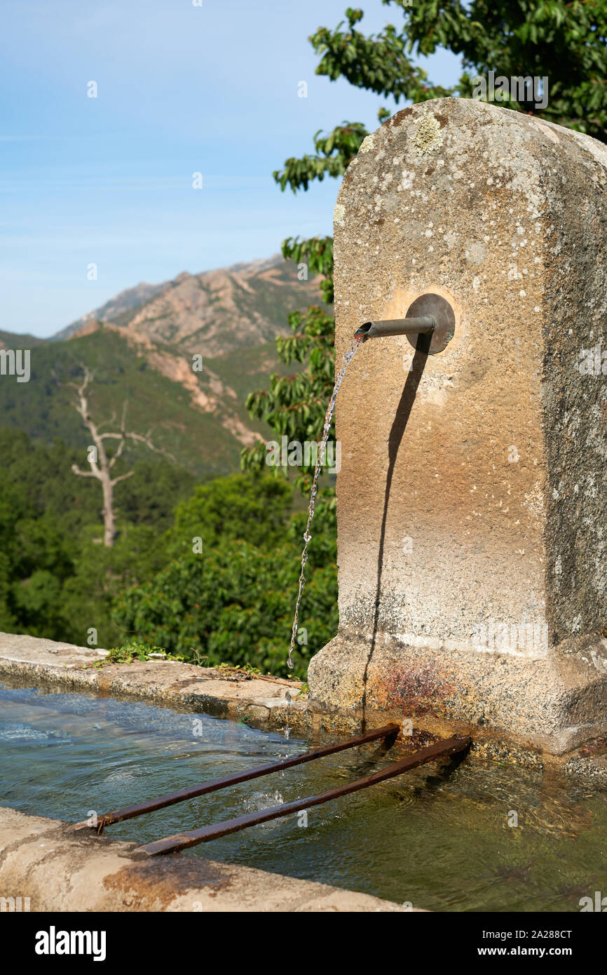 Une fontaine d'eau potable publique typique et le creux d'un village de montagne en Corse France. Banque D'Images