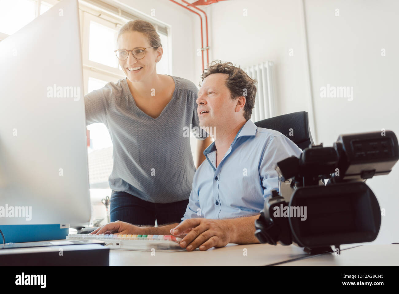 La femme et l'homme travaillant sur une vidéo en post-production Banque D'Images