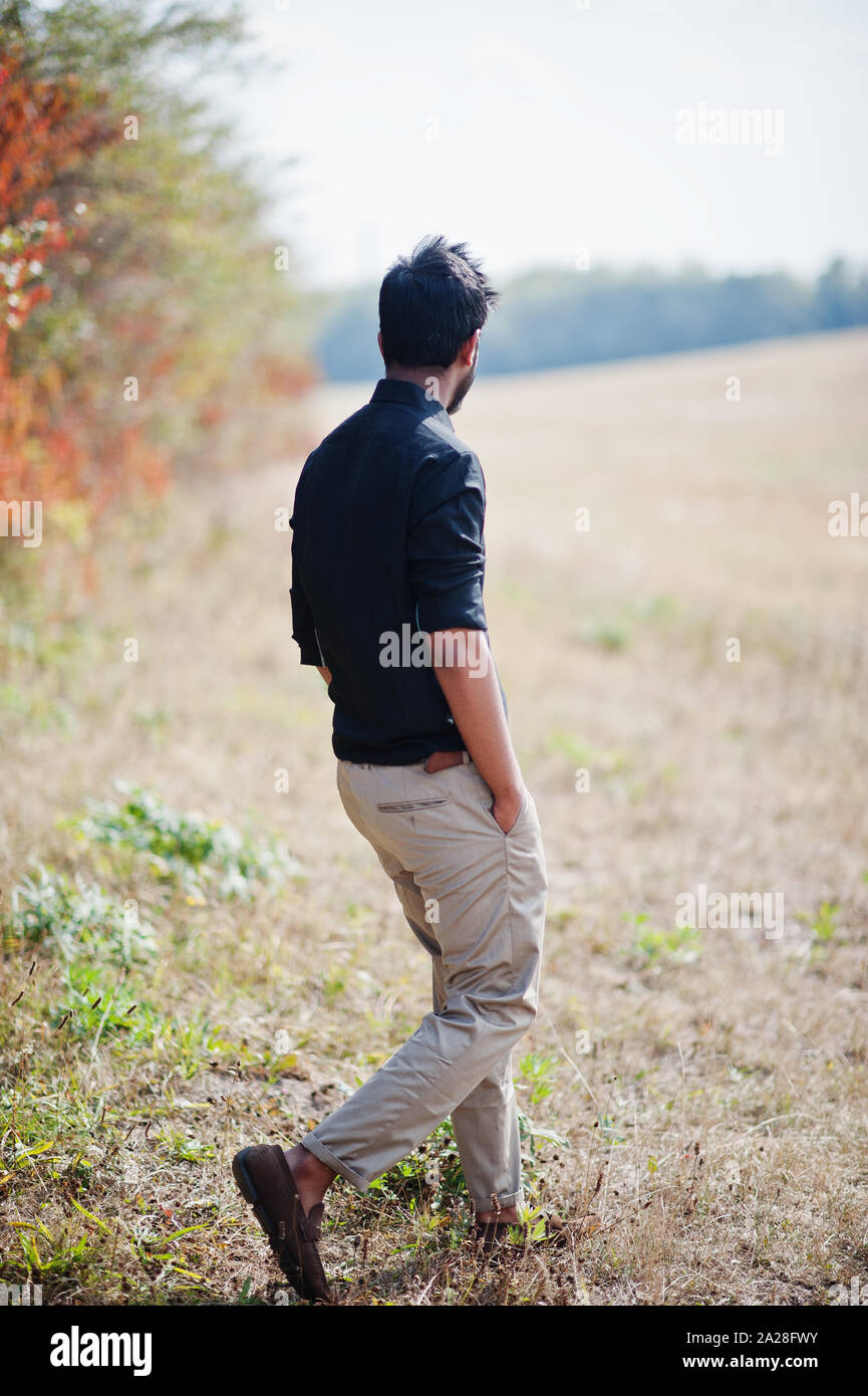 Indien à chemise noire et pantalon beige posés sur le terrain contre les  feuilles d'automne Photo Stock - Alamy