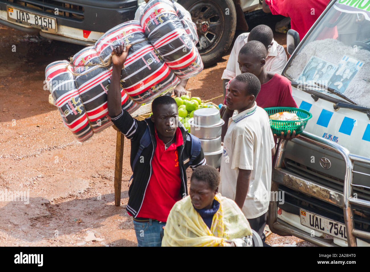 KAMPALA, OUGANDA - 03 octobre, 2012. Un homme porte un matelas au-dessus de sa tête au parc de taxi à Kampala, en Ouganda en octobre 03,2012. Banque D'Images